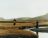 image from DIRTY Charity from photographer Nicci McClarron, shows two women standing in icelandic moorland, holding a large ribbon of fabric over a stream