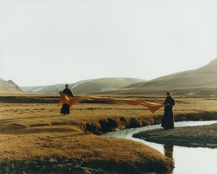 image from DIRTY Charity from photographer Nicci McClarron, shows two women standing in icelandic moorland, holding a large ribbon of fabric over a stream